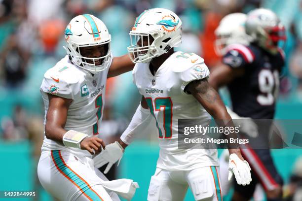 Jaylen Waddle of the Miami Dolphins celebrates with Tua Tagovailoa after scoring a touchdown during the second quarter against the New England...