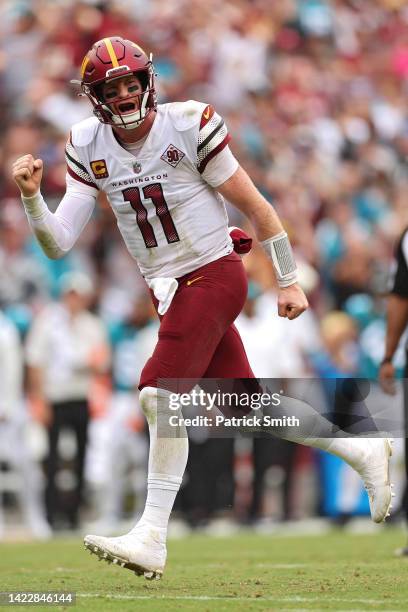 Quarterback Carson Wentz of the Washington Commanders celebrates after throwing a touchdown pass to wide receiver Jahan Dotson against the...