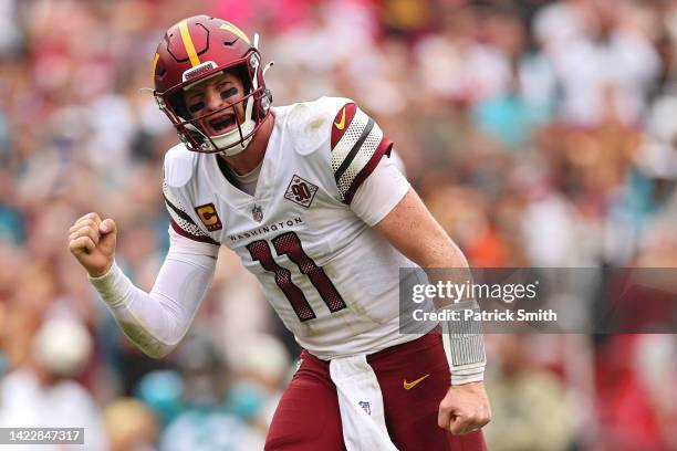 Quarterback Carson Wentz of the Washington Commanders celebrates after throwing a touchdown pass to wide receiver Jahan Dotson against the...