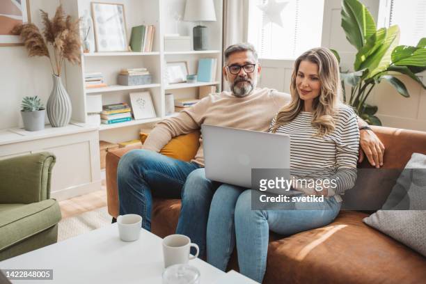 shopping from home - couple home laptop stock pictures, royalty-free photos & images