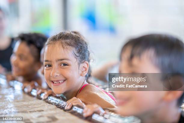 children at a swimming lesson - leren zwemmen stockfoto's en -beelden
