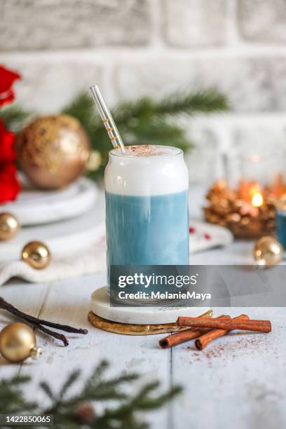 café con leche de té azul con guisante mariposa y espuma de leche en cocina rústica con decoraciones navideñas - clitoria fotografías e imágenes de stock