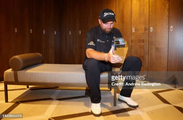 Shane Lowry of Ireland poses for a photograph with the BMW PGA Championship trophy in the player's locker room after winning the tournament during...