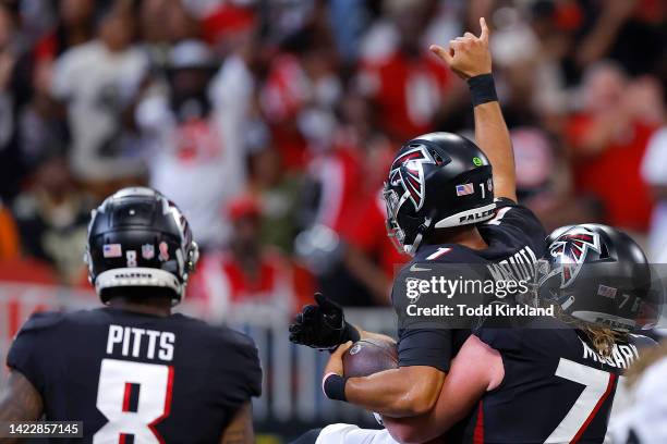 Quarterback Marcus Mariota of the Atlanta Falcons is lifted by offensive tackle Kaleb McGary of the Atlanta Falcons after Mariota's rushing touchdown...