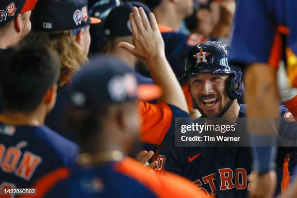 Alex Bregman of the Houston Astros is congratulated by teammates in the dugout after hitting a grand slam in the third inning against the Los Angeles...