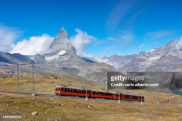 the iconic red train over the gornegrat railway, with the matterhorn mountain in background, zermatt, canton of valais, switzerland, europe - zermatt stock pictures, royalty-free photos & images