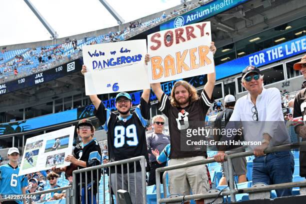 Fans hold signs about Baker Mayfield of the Carolina Panthers during the game against the Cleveland Browns at Bank of America Stadium on September...