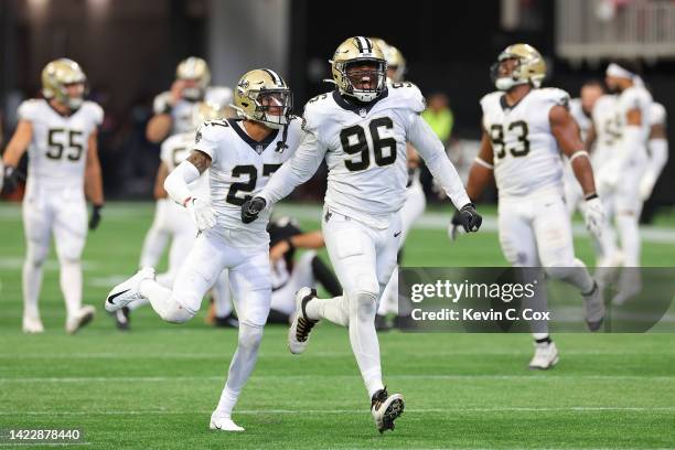 Cornerback Alontae Taylor of the New Orleans Saints and defensive end Carl Granderson of the New Orleans Saints celebrate a blocked game winning...