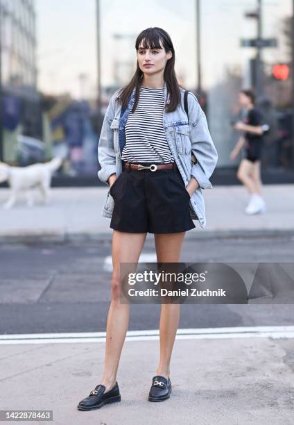 Model Bruna Ludtke is seen wearing a jean jacket, striped shirt, blue shorts, brown belt and Gucci shoes outside the Tibi show during New York...