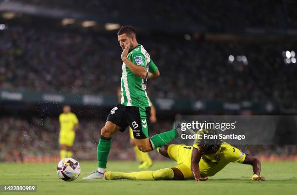 Aitor Ruibal of Real Betis is tackled by Samuel Chukwueze of Villarreal CF during the LaLiga Santander match between Real Betis and Villarreal CF at...