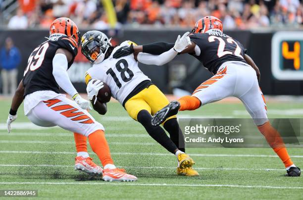 Wide receiver Diontae Johnson of the Pittsburgh Steelers slides while attempting to avoid linebacker Akeem Davis-Gaither of the Cincinnati Bengals...