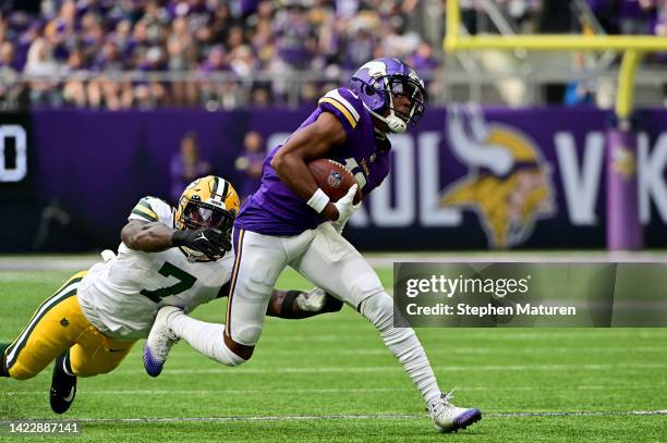 Justin Jefferson of the Minnesota Vikings avoids a tackle from Quay Walker of the Green Bay Packers during the first quarter at U.S. Bank Stadium on...