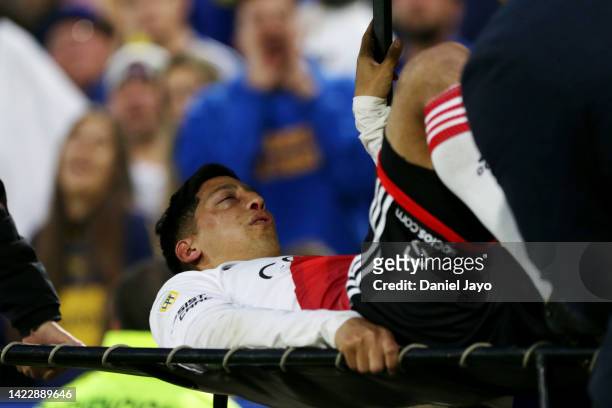 Rodrigo Aliendro of River Plate leaves the pitch in a medical cart after suffering an injury during a match between Boca Juniors and River Plate as...