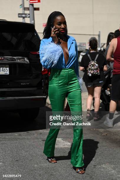 Guest is seen wearing a blue blouse, green pants outside the Patbo show during New York Fashion Week S/S 2023 on September 10, 2022 in New York City.