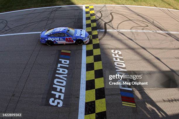 Bubba Wallace, driver of the ROOT Insurance Toyota, crosses the finish line to win the NASCAR Cup Series Hollywood Casino 400 at Kansas Speedway on...