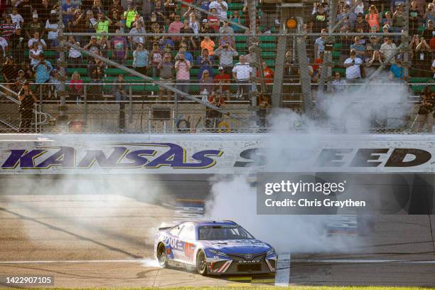 Bubba Wallace, driver of the ROOT Insurance Toyota, celebrates with a burnout after winning the NASCAR Cup Series Hollywood Casino 400 at Kansas...