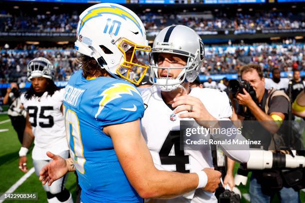 Quarterback Justin Herbert of the Los Angeles Chargers and quarterback Derek Carr of the Las Vegas Raiders hug at midfield after the Chargers 24-19...