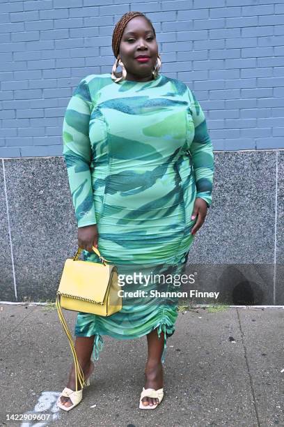 Guest wears a mid-length ruched long-sleeved green and blue watercolor print dress by ASOS and It's All Culture's big hoop earrings during September...