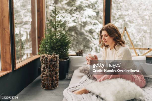 young beautiful woman wearing white bathrobe having breakfast in bed with coffee and croissant and fresh fruits in cozy bedroom. morning rituals. - wrapping arm stock pictures, royalty-free photos & images