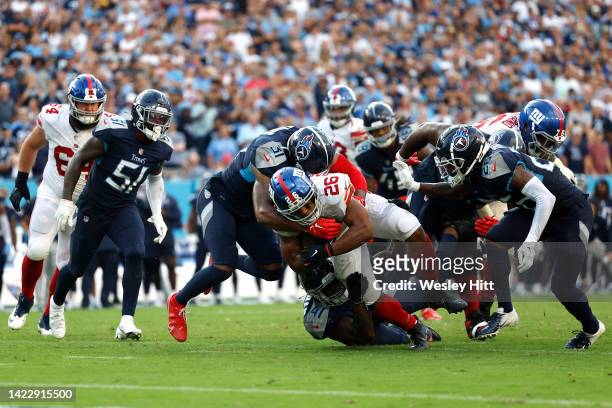 Safety Amani Hooker of the Tennessee Titans and linebacker Zach Cunningham of the Tennessee Titans tackle running back Saquon Barkley of the New York...