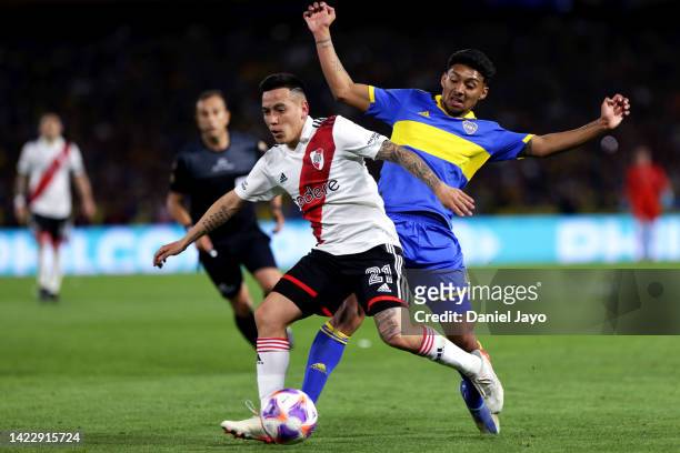 Esequiel Barco of River Plate battles for possession with Cristian Medina of Boca Juniors during a match between Boca Juniors and River Plate as part...