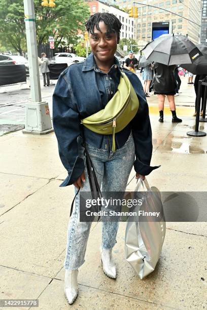 Arti Karina Sharif wears a thrifted dark denim rinse, peplum-waist jacket and acid-washed denim jeans with silver pointy-toed boots and an avocado...