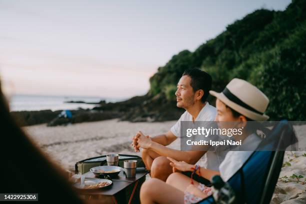 father looking at sunset on beach - asian family camping stock pictures, royalty-free photos & images