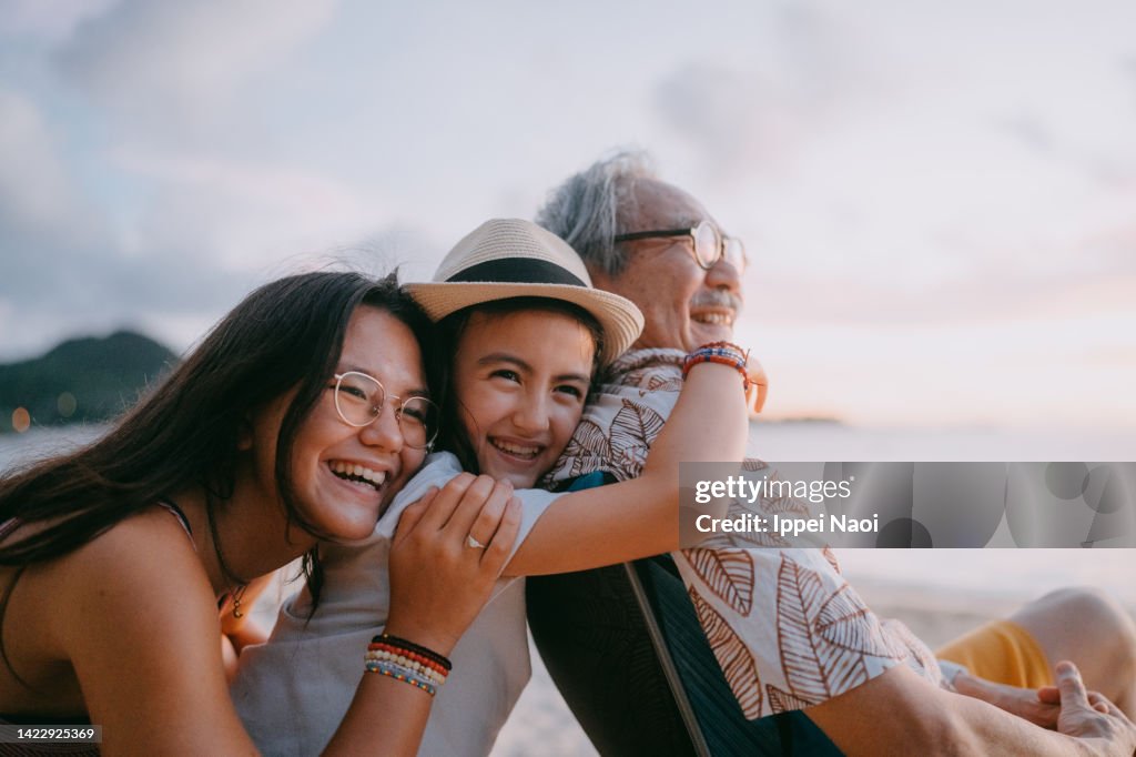 Grandfather and granddaughters having fun on beach