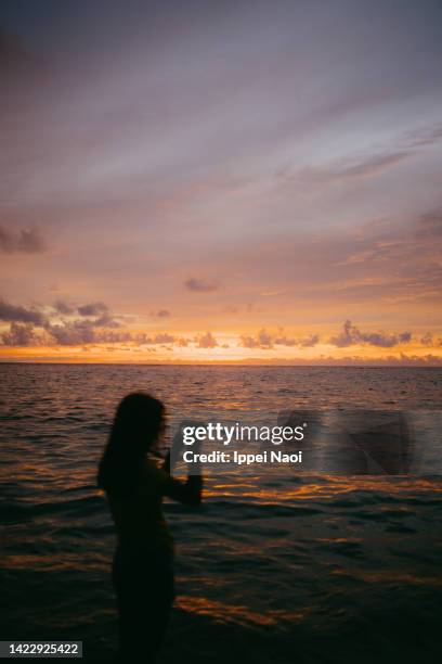 sunset over ocean with girl in silhouette - photographer seascape stock pictures, royalty-free photos & images