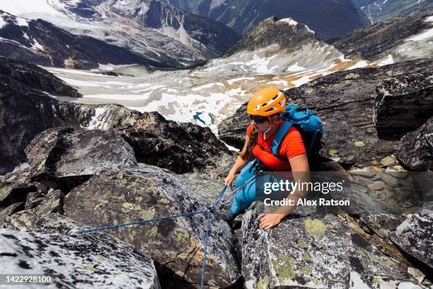 a women gets ready to rappel while mountain climbing - rock face stock pictures, royalty-free photos & images