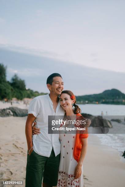 happy couple on tropical beach at dusk - the japanese wife foto e immagini stock