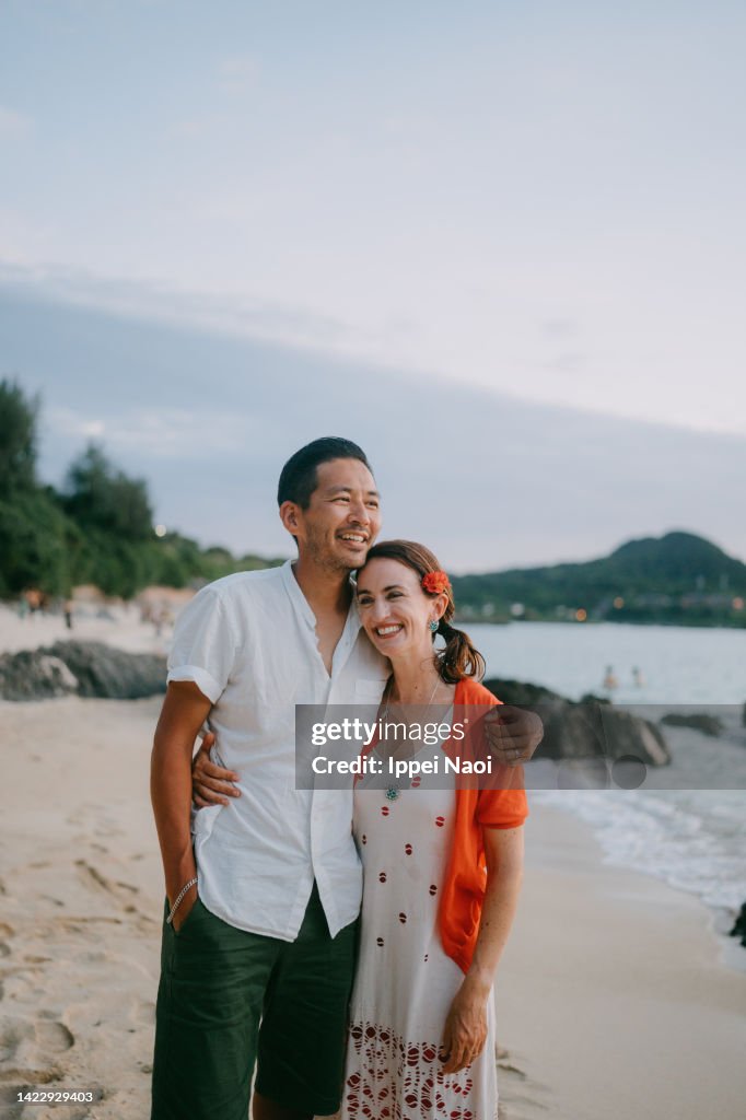 Happy couple on tropical beach at dusk