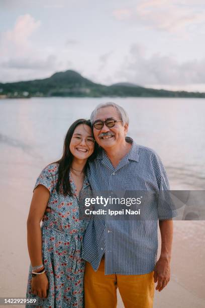 grandfather and granddaughter on beach at sunset - joue contre joue photos et images de collection