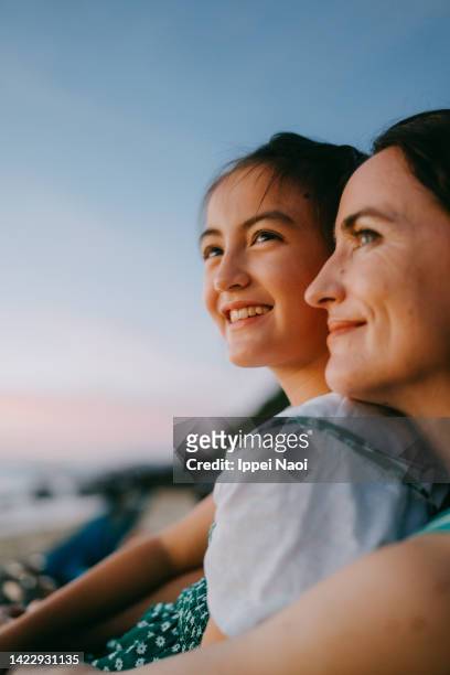mother and daughter enjoying sunset on beach - look familiar fotografías e imágenes de stock