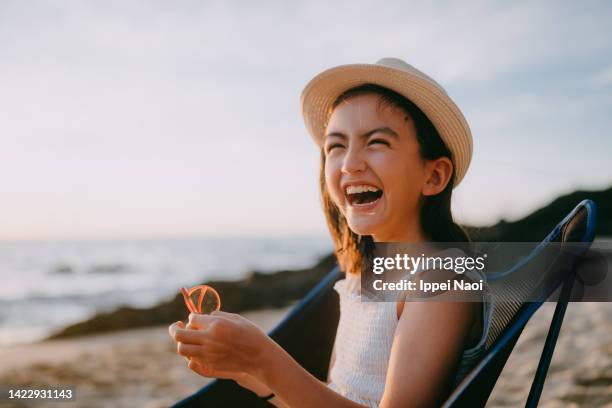 young girl having a good time on beach at sunset - eurasian stock pictures, royalty-free photos & images