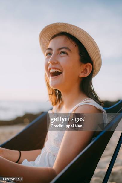 young girl having a good time on beach at sunset - girl side view stock-fotos und bilder