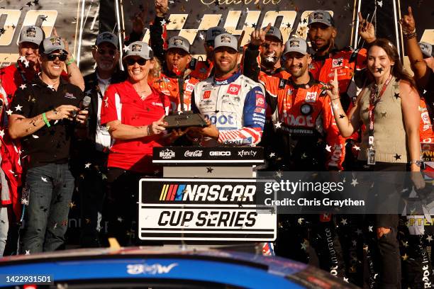 Bubba Wallace, driver of the ROOT Insurance Toyota, receives the Kansas Speedway Casino 400 trophy in victory lane after winning the NASCAR Cup...