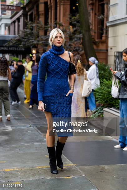 Devon Windsor blue knitted dress, black mid high boots wearing outside Puppets & Puppets on September 11, 2022 in New York City.