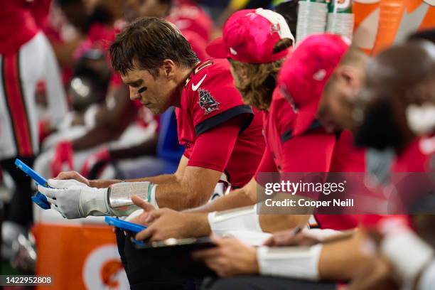 Tom Brady of the Tampa Bay Buccaneers looks at a Microsoft Surface tablet on the sideline against the Dallas Cowboys at AT&T Stadium on September 11,...