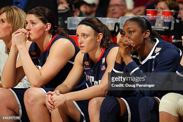 Stefanie Dolson, Kelly Faris and Brianna Banks of the Connecticut Huskies look on from the bench in the second half after Dolson returned to the...