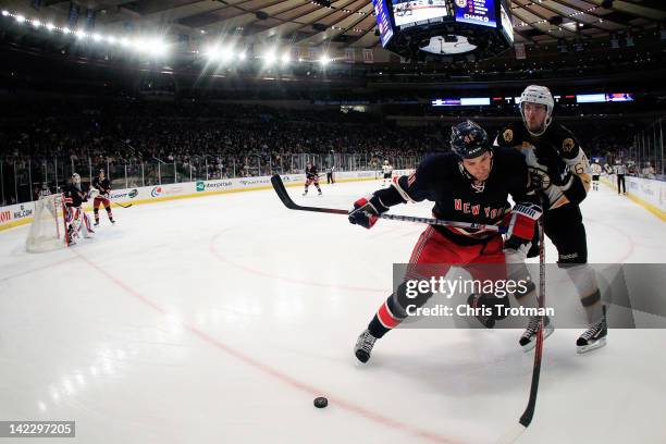 Stu Bickel of the New York Rangers is challenged by Benoit Pouliot of the Boston Bruins at Madison Square Garden on April 1, 2012 in New York City.