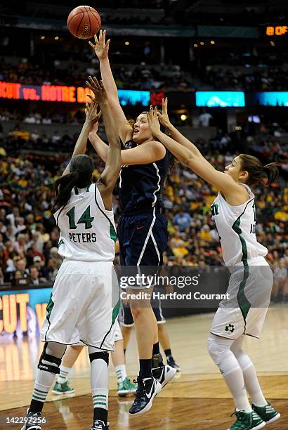 Stefanie Dolson of Connecticut is double teamed by Devereaux Peters, left, and Natalie Achonwa, right, of Notre Dame during the first half of the...