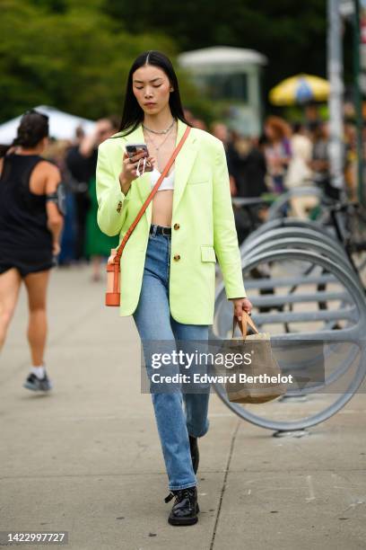 Guest wears silver chain necklaces, a white V-neck bra underwear, a brown shiny leather water bottle holder, a beige matte metallic water bottle, a...