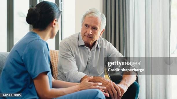 retirement home, elderly and healthcare caregiver taking care of senior man for his health, support and wellness. physiotherapy, doctor or nurse listening to old patient for medical problems - man talking to doctor bildbanksfoton och bilder