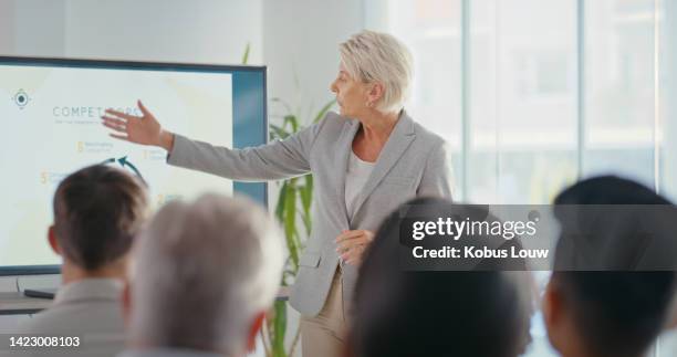 business woman giving a presentation at a corporate conference in a modern office building. global company manager doing leadership, development and management training with employees at a workshop. - senior people training imagens e fotografias de stock