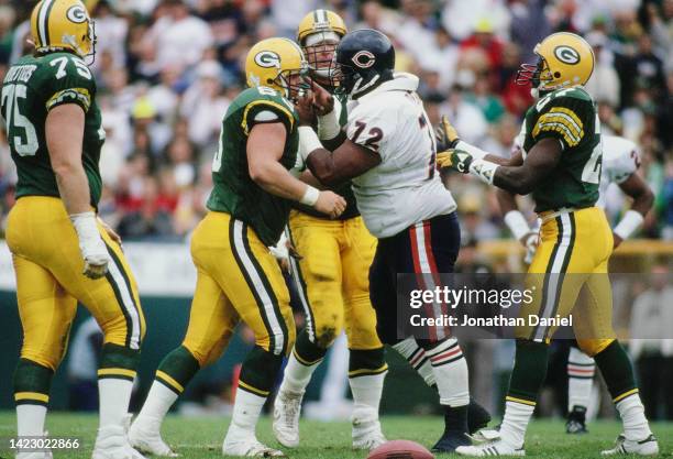 William the Refrigerator Perry, Defensive Tackle for the Chicago Bears grabs the face guard and points a finger at James Campen, Center for the Green...