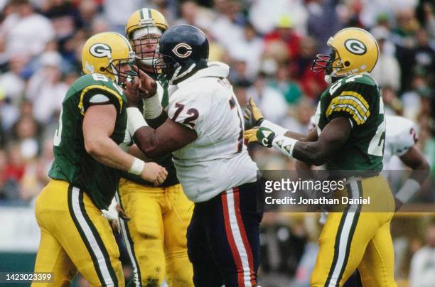 William the Refrigerator Perry, Defensive Tackle for the Chicago Bears grabs the face guard and points a finger at James Campen, Center for the Green...