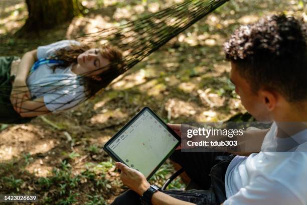 reisende im millennial-alter, die auf einem digitalen tablet auf eine karte schauen, während sie die natur genießen - tablet paar sommer stock-fotos und bilder