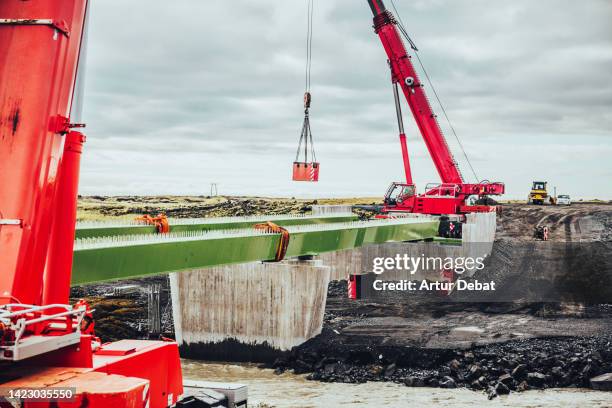 big cranes building new bridge connection in the ring road highway of iceland. - beam bridge stock pictures, royalty-free photos & images