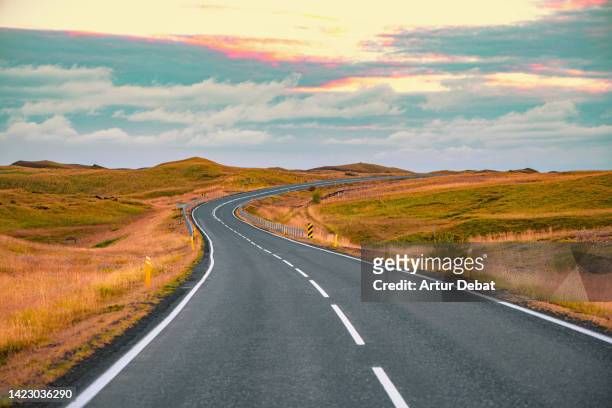 iceland road with vanishing point and curve in the south of iceland. - horizon over land road stock pictures, royalty-free photos & images